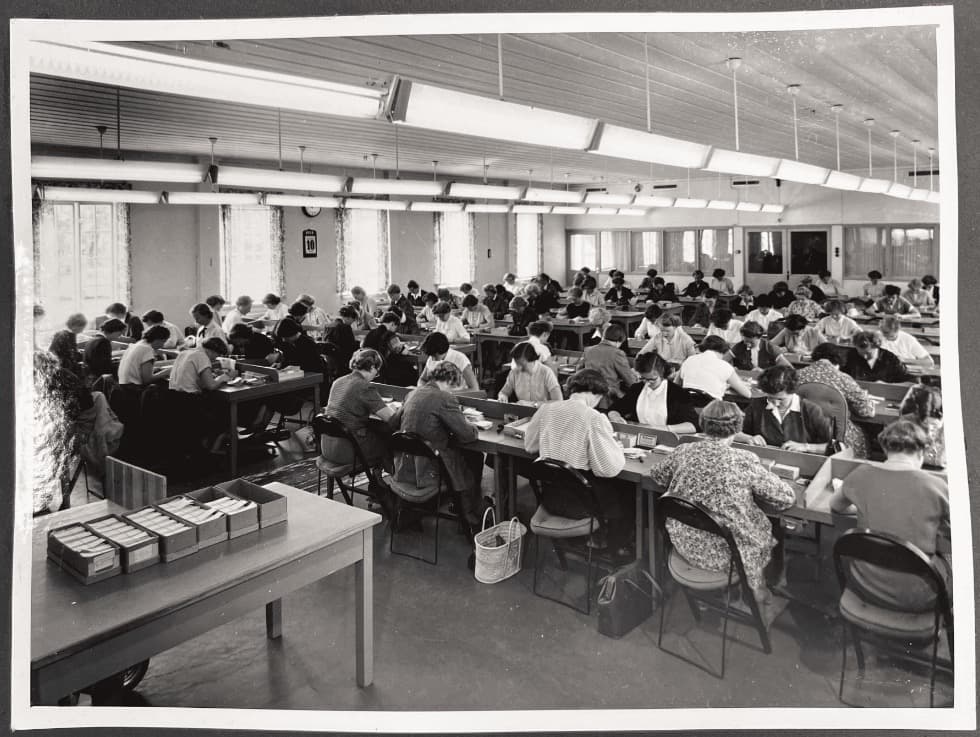 Arkivbildet av annsatte som gransker kuponger i 1954.